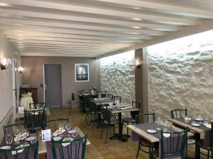 Un comedor con mesas y sillas con copas de vino. en Le Relais d'Etagnac, en Étagnac