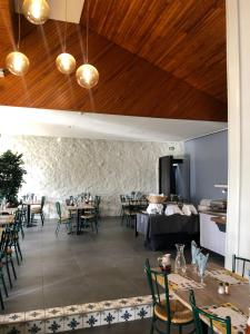 a restaurant with tables and chairs and wooden ceilings at Le Relais d'Etagnac in Étagnac