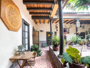an outdoor patio with a wooden table and potted plants at Hotel del Carmen in Tlalpujahua de Rayón