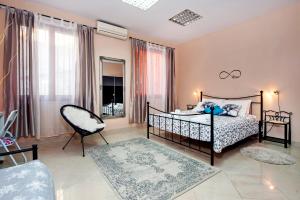 a bedroom with a bed and a chair at Rovinj City Apartment in Rovinj