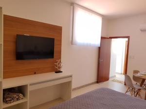 1 dormitorio con TV de pantalla plana en la pared en Apartamento de Luxo Família, en Prado