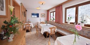 a restaurant with two tables and chairs and windows at Hotel Sonne in Tux