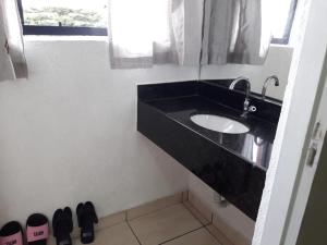 baño con lavabo negro y espejo en Motel Softy (Adults Only) en Osasco