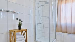 ein Bad mit einer Dusche und einem Tisch mit Handtüchern in der Unterkunft Hotel Frankenthaler Hof in Frankenthal + 37 Fotos