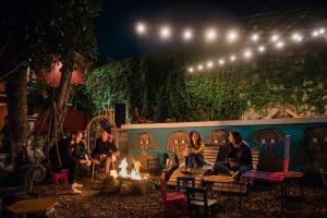a group of people sitting around a fire at night at Socialtel Antigua in Antigua Guatemala