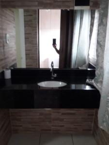 een badkamer met een wastafel en een spiegel bij Motel Softy (Adults Only) in Osasco
