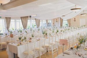 a wedding banquet room with white tables and chairs at Deans Place Hotel in Alfriston