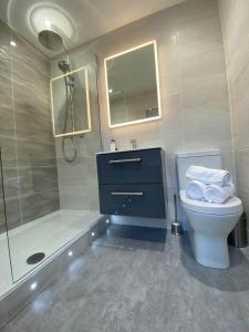 La salle de bains est pourvue d'un lavabo, de toilettes et d'une douche. dans l'établissement Womack Lodge, à St Helens