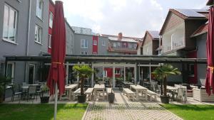 a patio with tables and chairs and buildings at Adesso Hotel Göttingen - pay at property on arrival-Ihr Automatenhotel in Göttingen in Göttingen