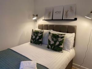 a bedroom with a bed with white sheets and green pillows at Womack Lodge in Saint Helens