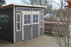 a small shed with a door on a patio at Pension an der Havel in Havelberg