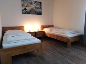 two twin beds in a room with a light at Ferienhaus No.10 in Hemmoor