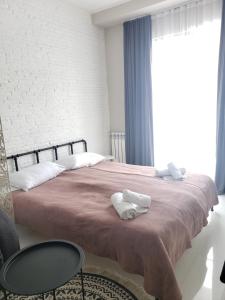 a bedroom with a bed with two towels on it at Tatiana Gudauri in Gudauri