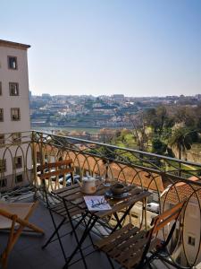 a table and chairs on a balcony with a view at Tripas-Coração, Cordoaria River View, Garden View or Loft in Porto