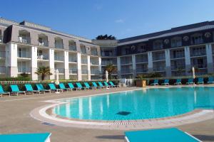 a swimming pool in front of a large building at Surcouf in Douarnenez