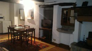 un salon avec une table à manger et une télévision dans l'établissement Short Rent Il Casale, à Capolona
