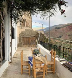 einen Tisch und Stühle auf einem Balkon mit Aussicht in der Unterkunft Casilla Cantón in Canjáyar