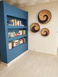 una habitación con dos estanterías y una pared con libros en Apartamentos Guadiana, en Monte Gordo