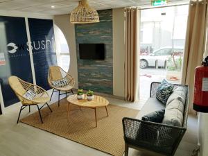 a living room with a couch and chairs and a table at Apartamentos Guadiana in Monte Gordo