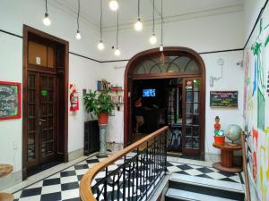 a restaurant with a staircase in a room with a checkered floor at Rivera Hostel Córdoba in Córdoba