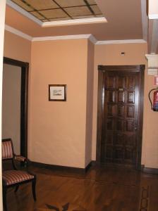 a hallway with a wooden door and a chair at Hotel Mauleon in Legazpia