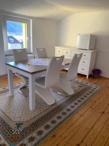 ein Esszimmer mit einem Tisch und 4 Stühlen in der Unterkunft Seerestaurant & Suiten Hayat in Steindorf am Ossiacher See