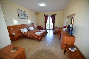 Habitación de hotel con cama y TV en Anaxos Hotel, en Anaxos