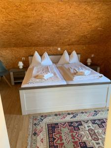 ein Bett mit weißer Bettwäsche und Kissen darauf in der Unterkunft Seerestaurant & Suiten Hayat in Steindorf am Ossiacher See