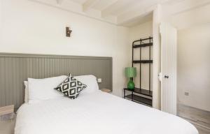 a bedroom with a white bed and a green lamp at Fern Cottage in Killinaboy