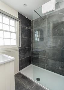 een badkamer met een douche, een wastafel en een bad bij Fern Cottage in Killinaboy