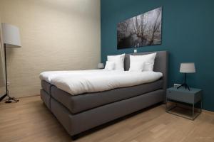 1 dormitorio con 1 cama grande y paredes azules en Péitche Lauer, en Useldange