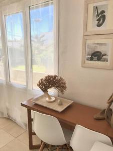 a dining room table with two white chairs and a window at CALA BLANCA-TORRE BELLVER in Cala Blanca