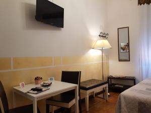 Cette petite chambre dispose d'une table et d'une télévision murale. dans l'établissement Locazione Turistica Cittadella, à Vérone
