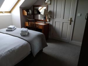 a bedroom with a bed and a desk and a window at Glen Gat House in Dundalk