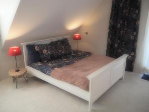 a bedroom with a white bed with two lamps on it at Bed & Brochje Burgum in Burgum