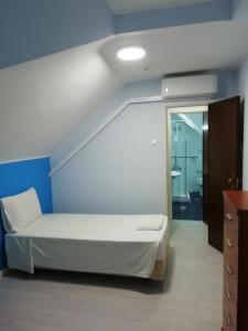 um quarto com uma cama branca e uma parede azul em Residencial Camoes em Lisboa