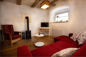 a living room with a red couch and a chair at Am Lindenbaum in Friedrichshafen