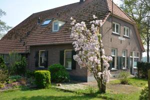 una casa con un albero da fiore di fronte di De Viersprong a Laren