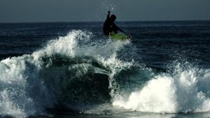 a man riding a wave on a surfboard in the ocean at AFIFE "Porta da Alegria" in Viana do Castelo
