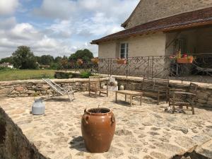 a patio of a house with a vase and chairs at Chez sandrine in Mouhet