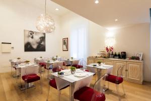 a dining room with white tables and red chairs at La Ciliegina Lifestyle Hotel in Naples