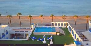 a house with a swimming pool next to the beach at Hotel Marlin Antilla Playa in La Antilla