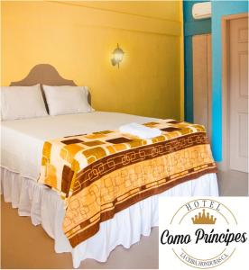 Una cama con una manta en una habitación en Hotel Como Principes, en La Ceiba