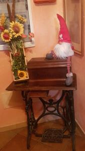 un gnome assis au-dessus d'un piano à côté des fleurs dans l'établissement Agriturismo Dinoabbo Apt, à Lucinasco