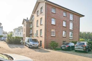 ein Backsteingebäude mit zwei davor geparkten Autos in der Unterkunft Haus Roland Wohnung 11 in Zinnowitz
