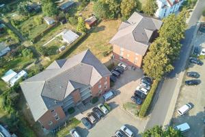 Draufsicht auf ein Haus mit Autos auf einem Parkplatz in der Unterkunft Haus Roland Wohnung 11 in Zinnowitz