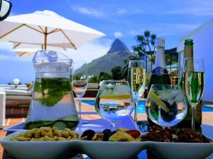 einen Tisch mit Weingläsern und einen Teller mit Essen in der Unterkunft Diamond House Guesthouse in Kapstadt