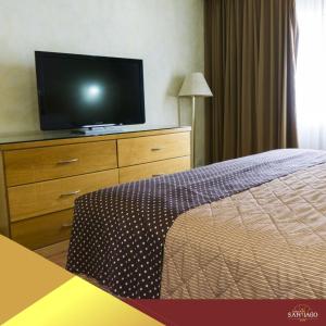 Dormitorio con cama y tocador con TV en Hotel Santiago Plaza, en Hermosillo