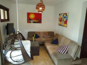 a living room with two couches and a tv at Apto Pipa Beleza Spa Resort in Pipa +16 photos