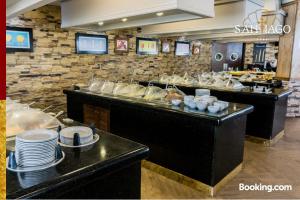 un restaurante con una línea de buffet con platos y platos en Hotel Santiago Plaza, en Hermosillo